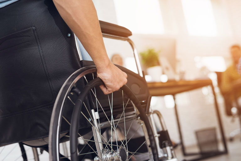 Ein invalider Mann sitzt in einem Rollstuhl